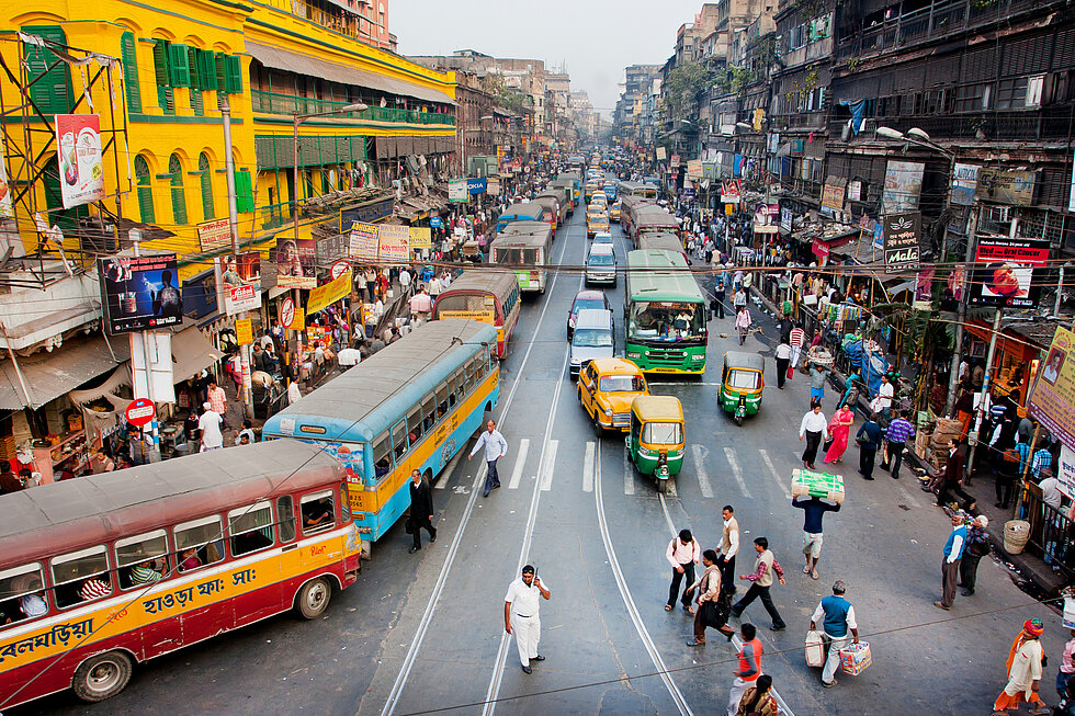 Traffic jam with hundreds of city taxi, buses and pedestrians of busy city road in Kolkata, India 