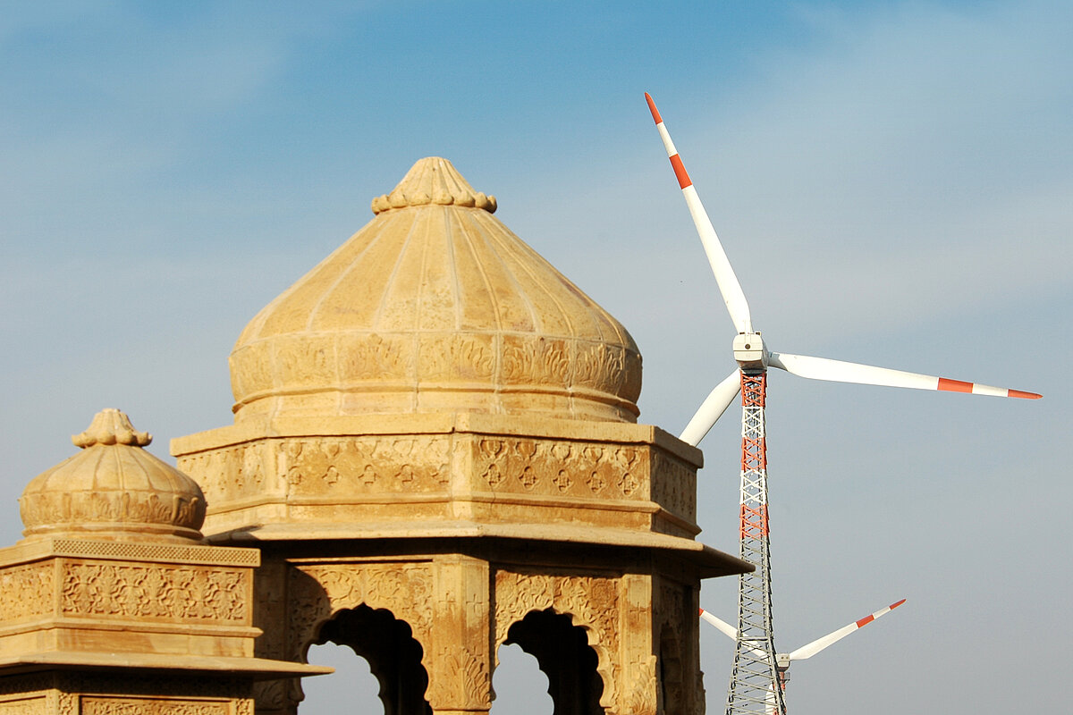 Wind turbines behind an ancient architecture in Rajasthan, India.