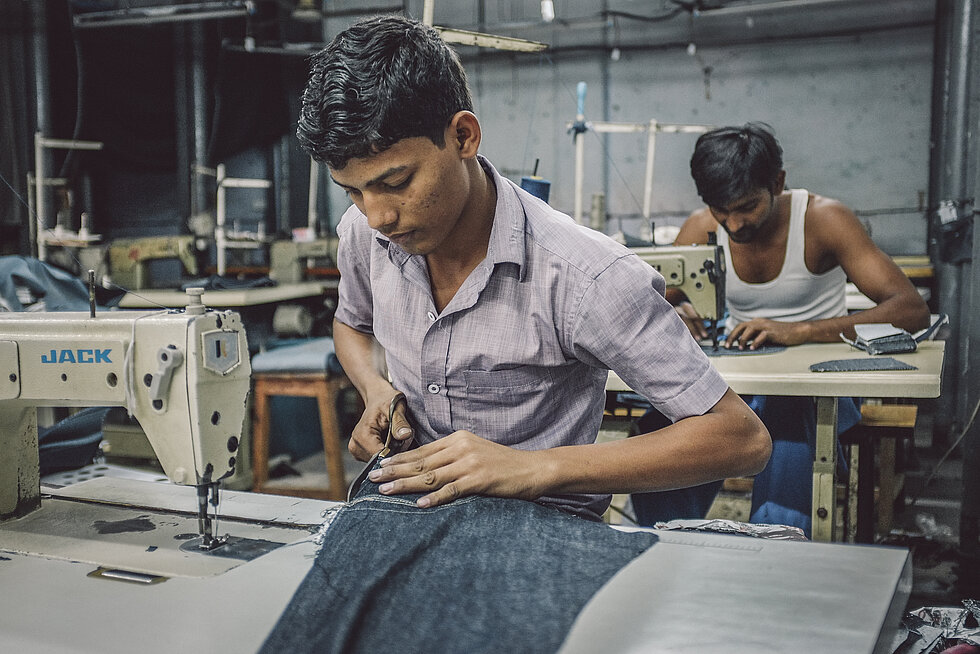 Indian workers sew in clothing factory.