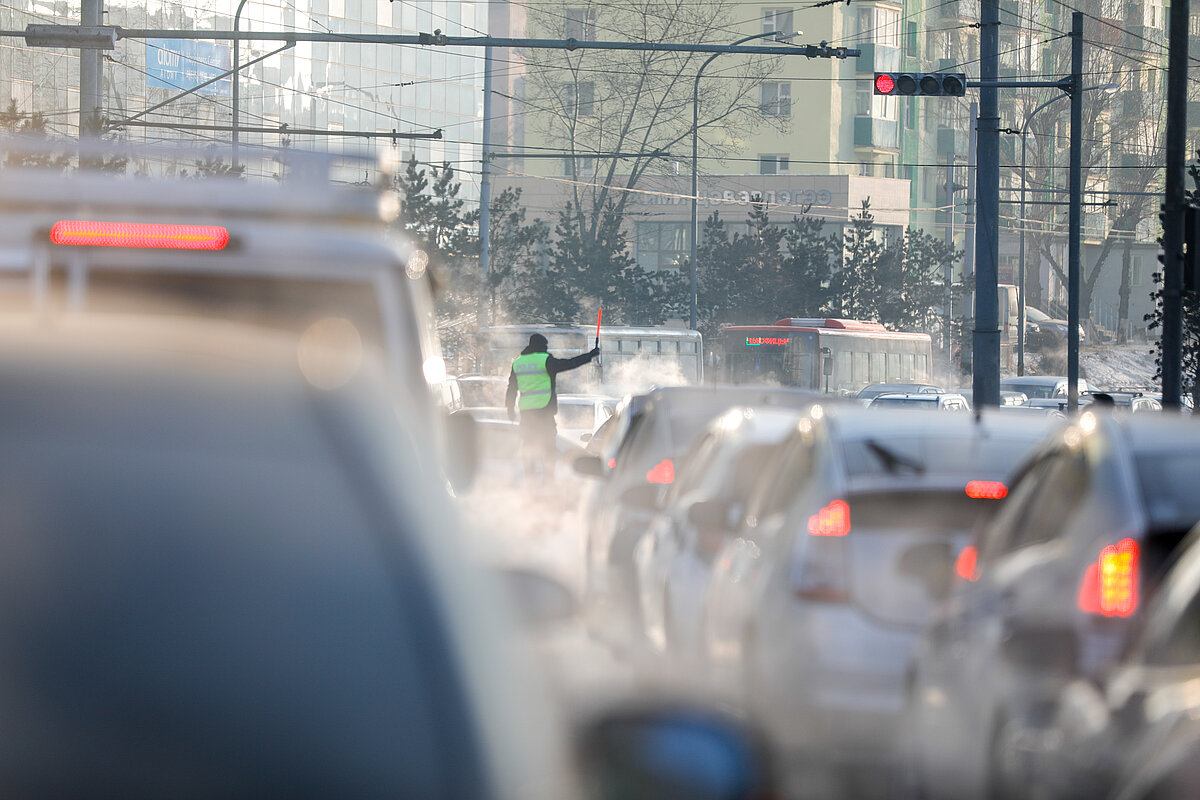 A traffic police facilitating the flow of commuters in the middle of heavy traffic jam in the city