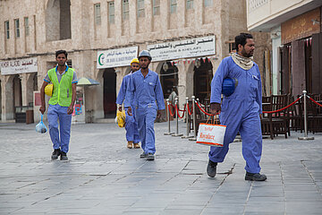 Four construction workers walking on the streets