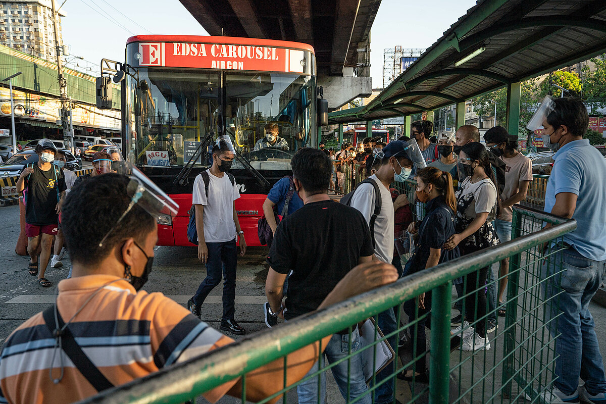 Commuters rush as they board the public utility buses at designated bus lanes along EDSA, Quezon City. 