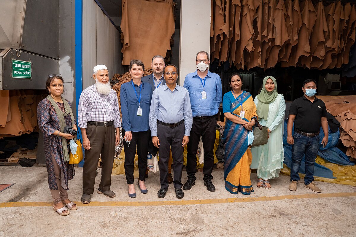 A group photo consisting of 9 people taken in front of a tannery factory in Bangladesh.