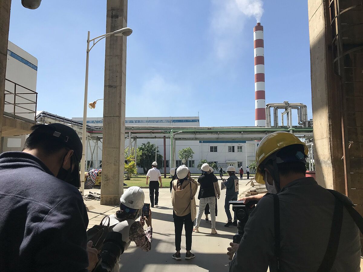 Vietnamese journalists look at the gas-flue stacks at Hai Phong 1 coal-fired power plant